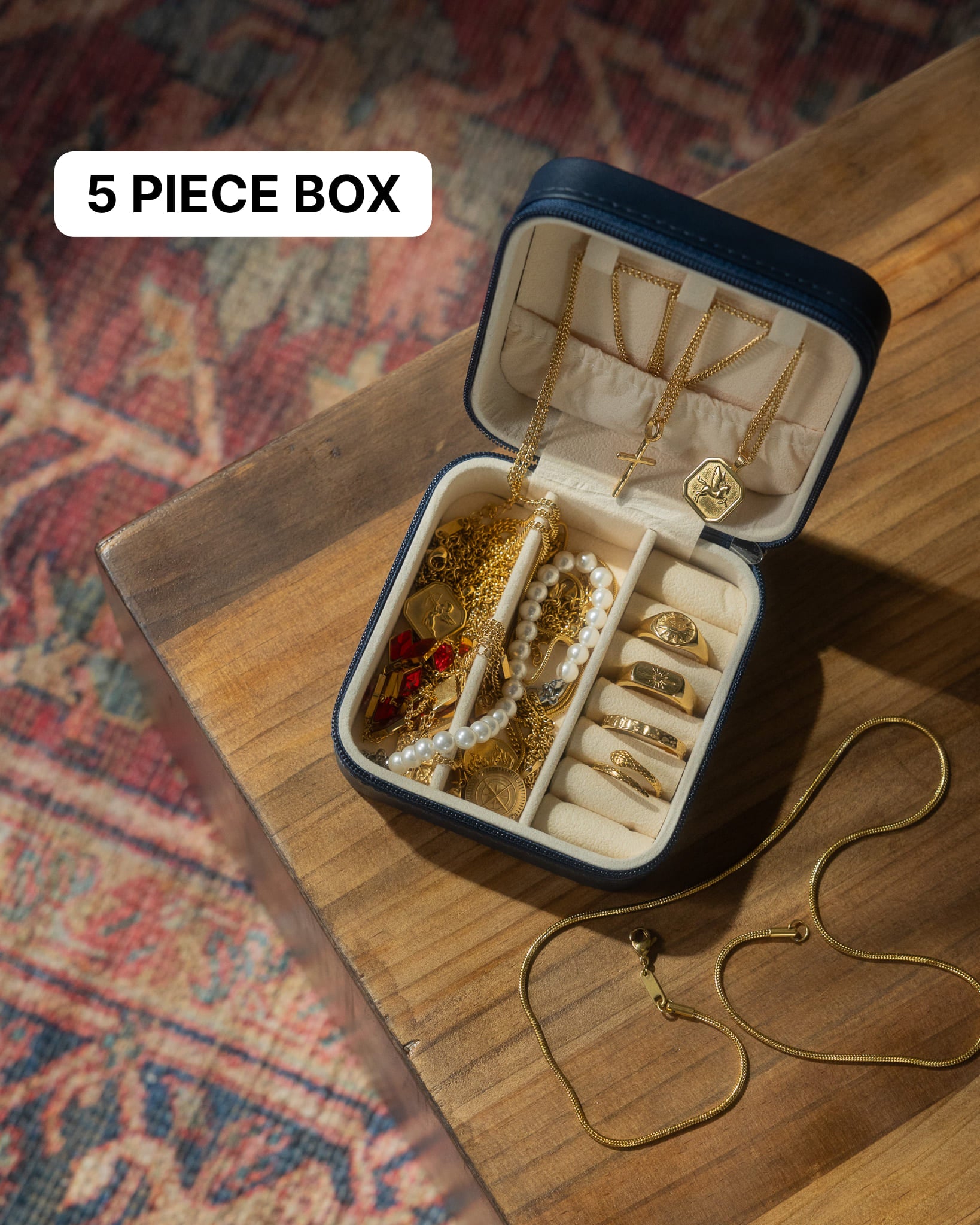 Open jewelry case showing gold chains pendants and a pearl bracelet inside