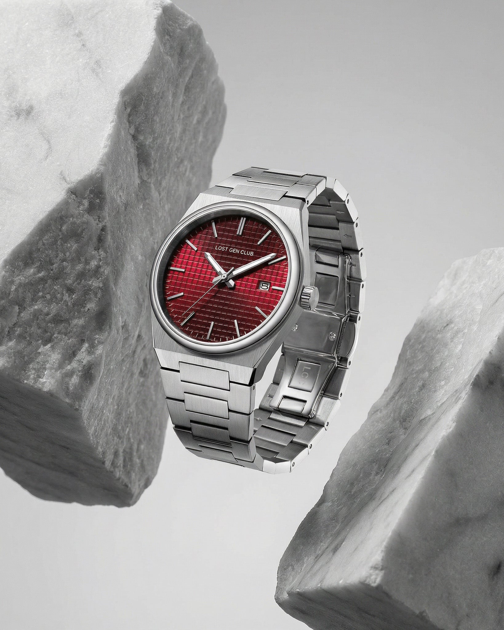 AUREN WATCH with stainless steel bracelet and a red textured dial against a rocky backdrop