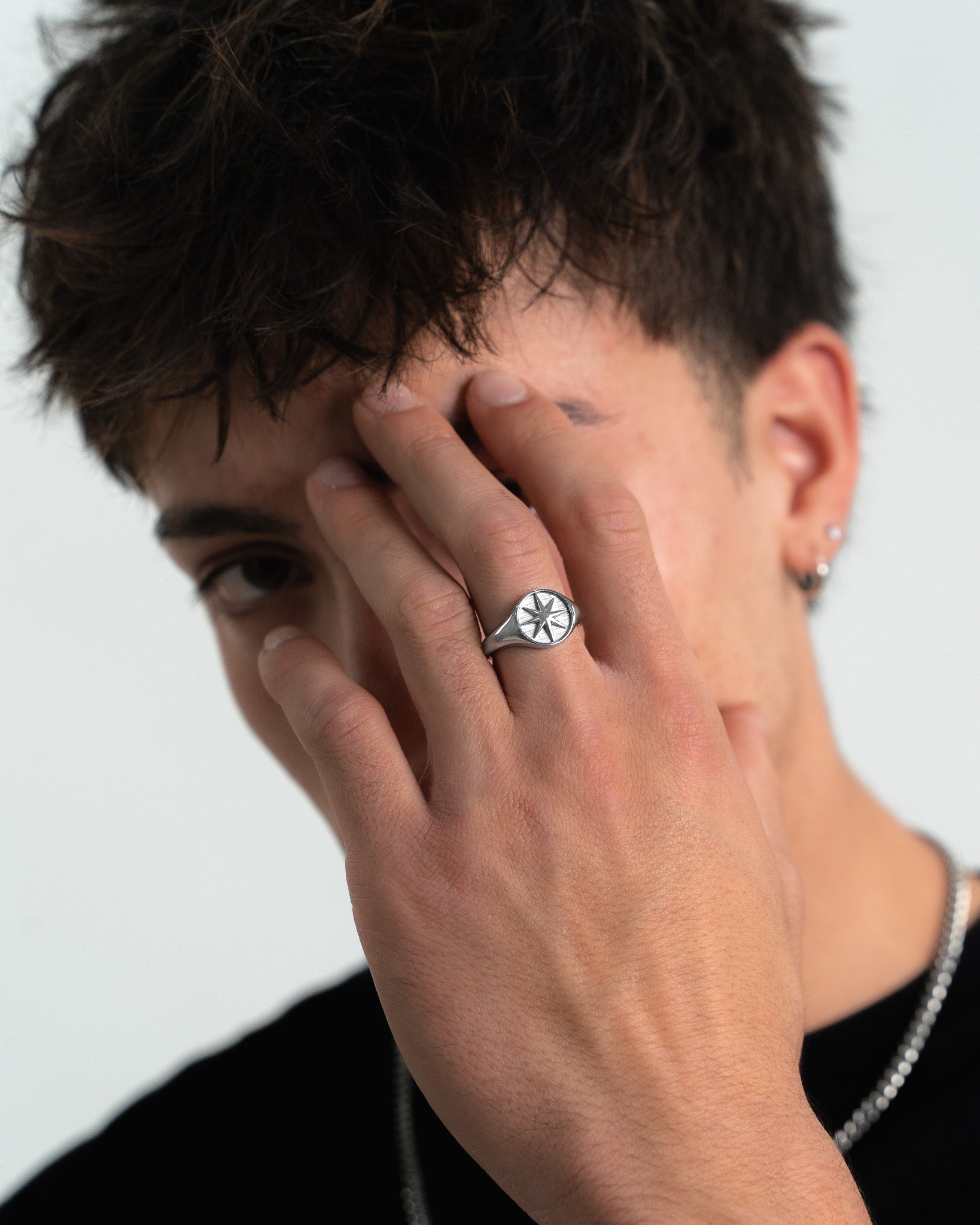 Primer plano del STAR SILVER RING en el dedo de un hombre mostrando un diseño limpio y combinable.