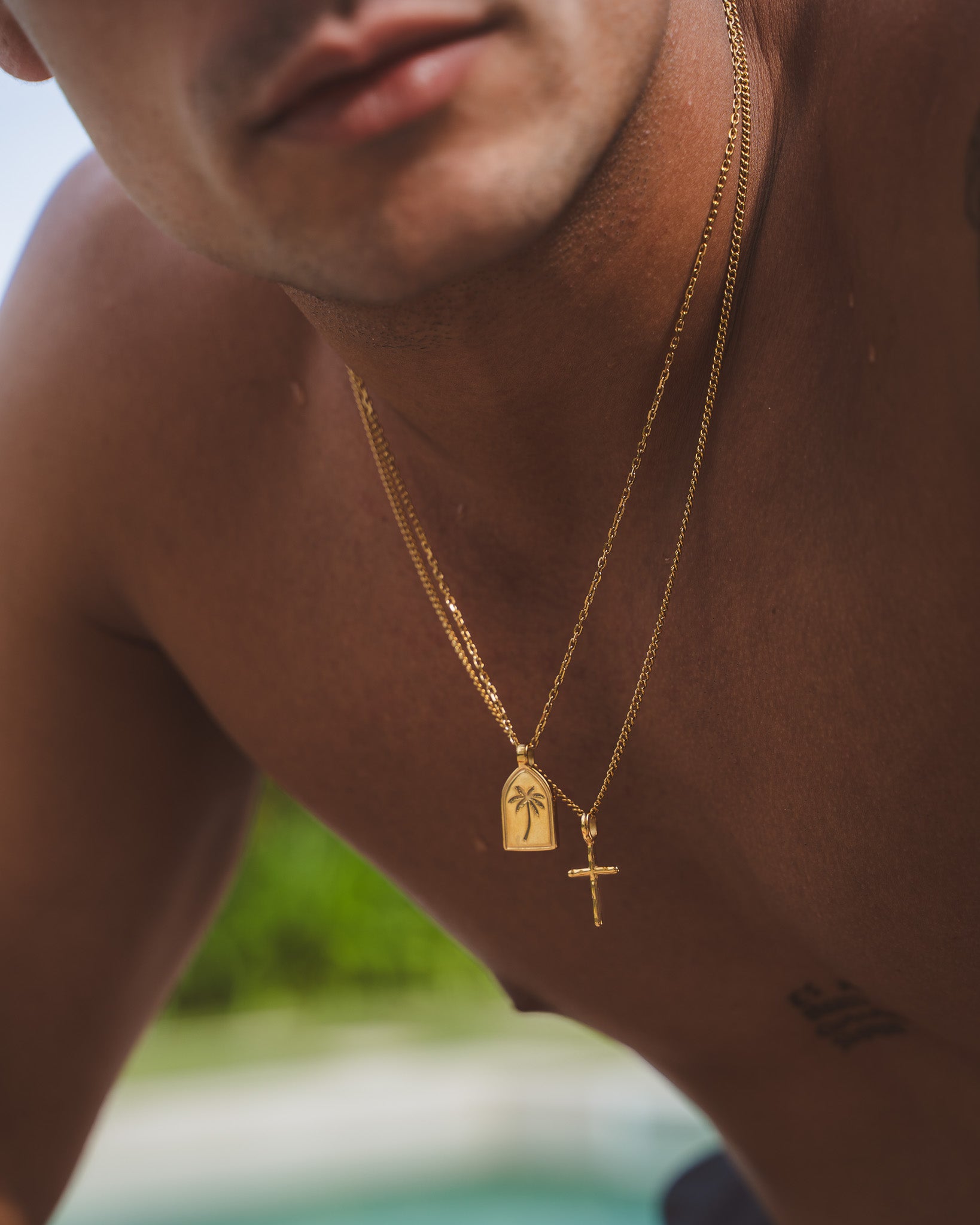 Gold Palm Gold Necklace worn on the neck with a palm tree pendant and layered chains
