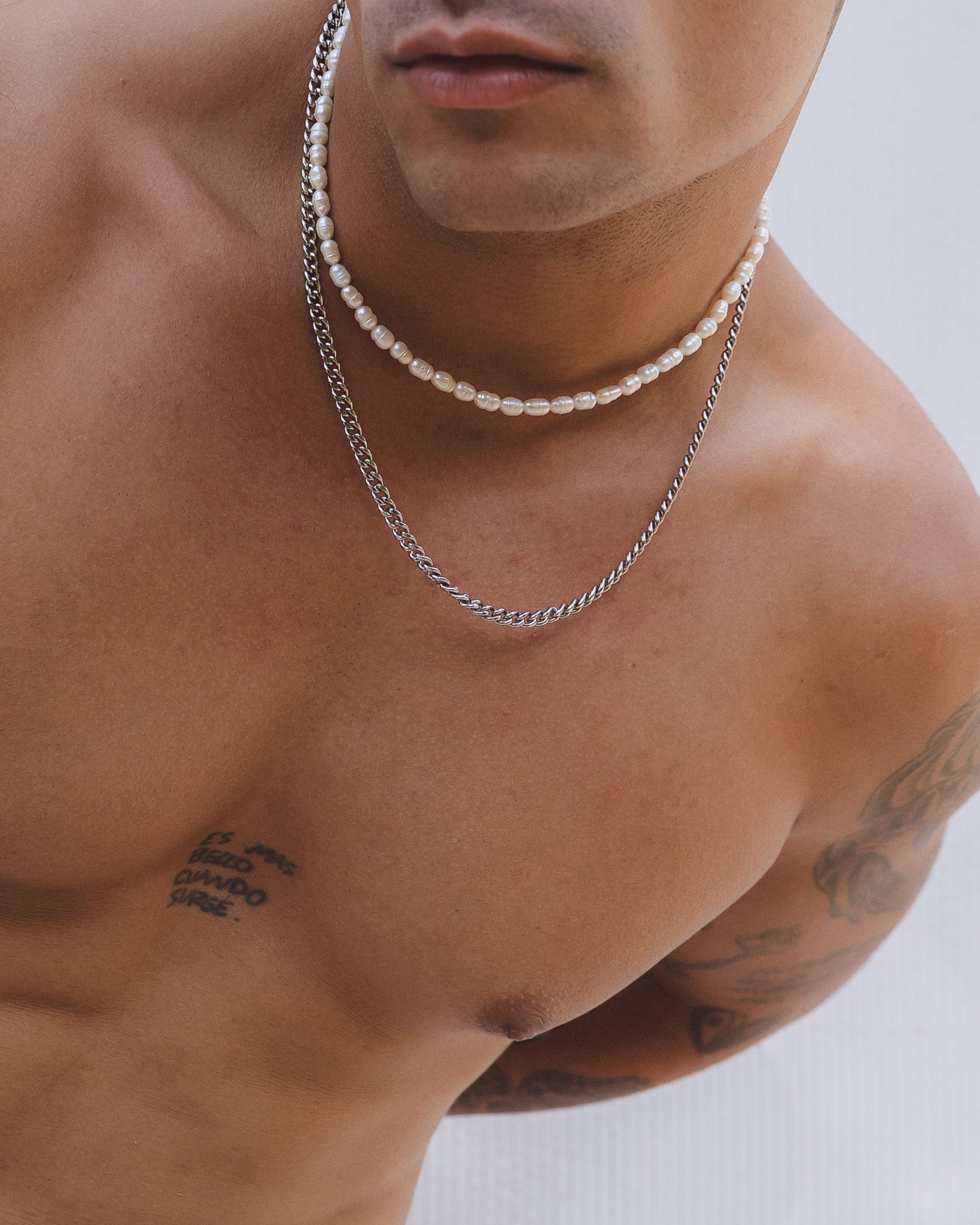 Two layered necklaces on the neck a Belize Pearl Chain with cream freshwater pearls and a silver chain