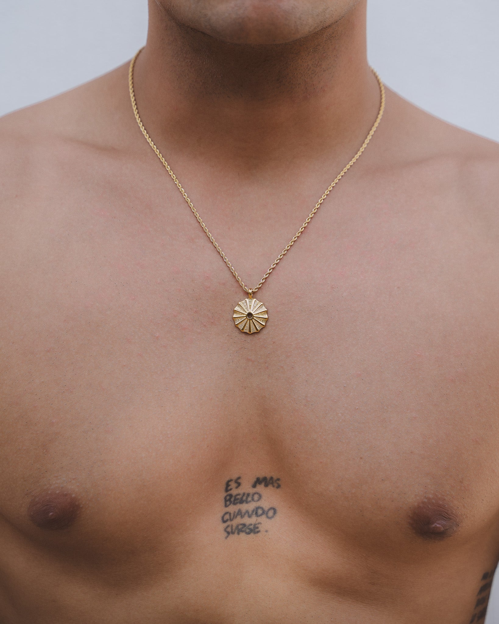 Gold sunburst pendant on a 50 cm adjustable chain resting at the collarbone