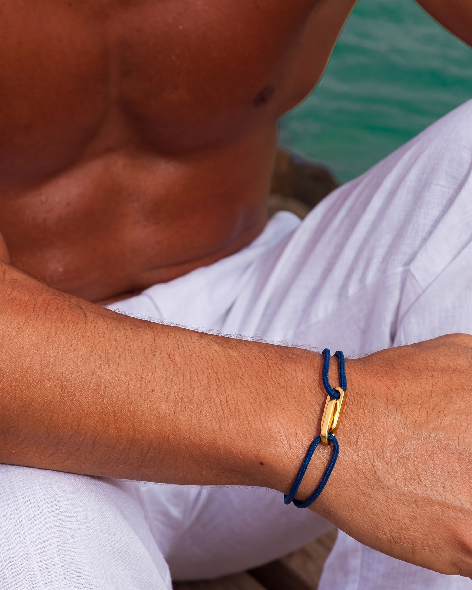 Pulsera ATLANTIS de oro con cordón azul y cierre de oro en la muñeca