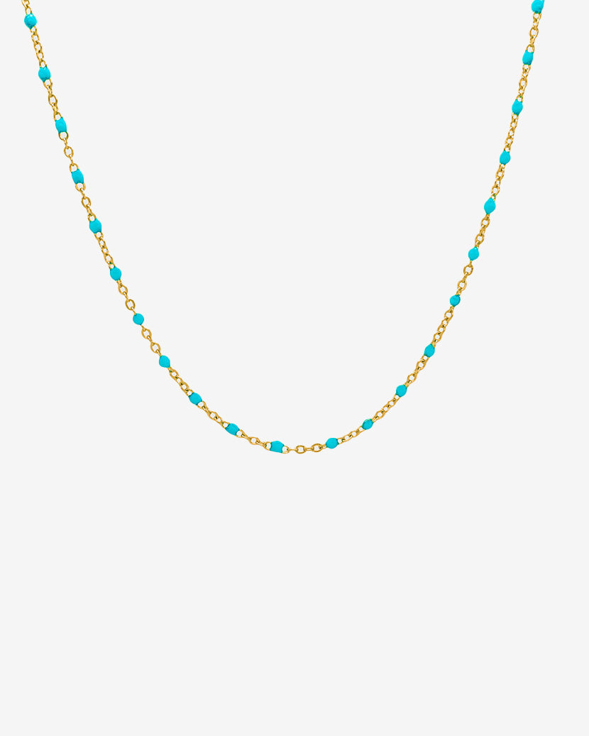 Gold chain necklace with turquoise beads displayed on a white background