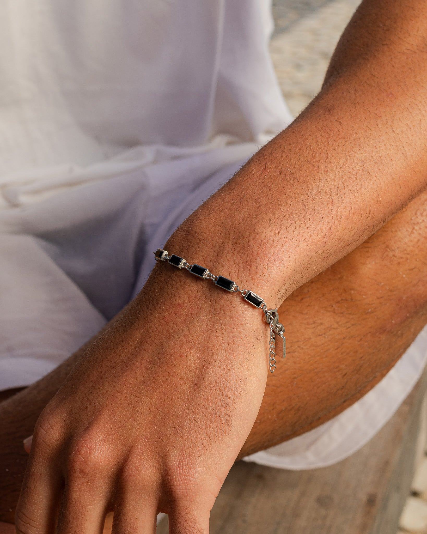 Omen silver bracelet with black rectangular stones worn on a forearm