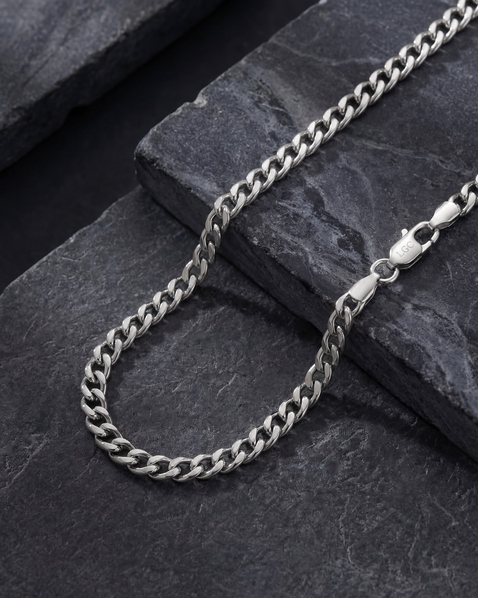 Cuban silver chain 5mm Cuban link laid on a dark slate surface