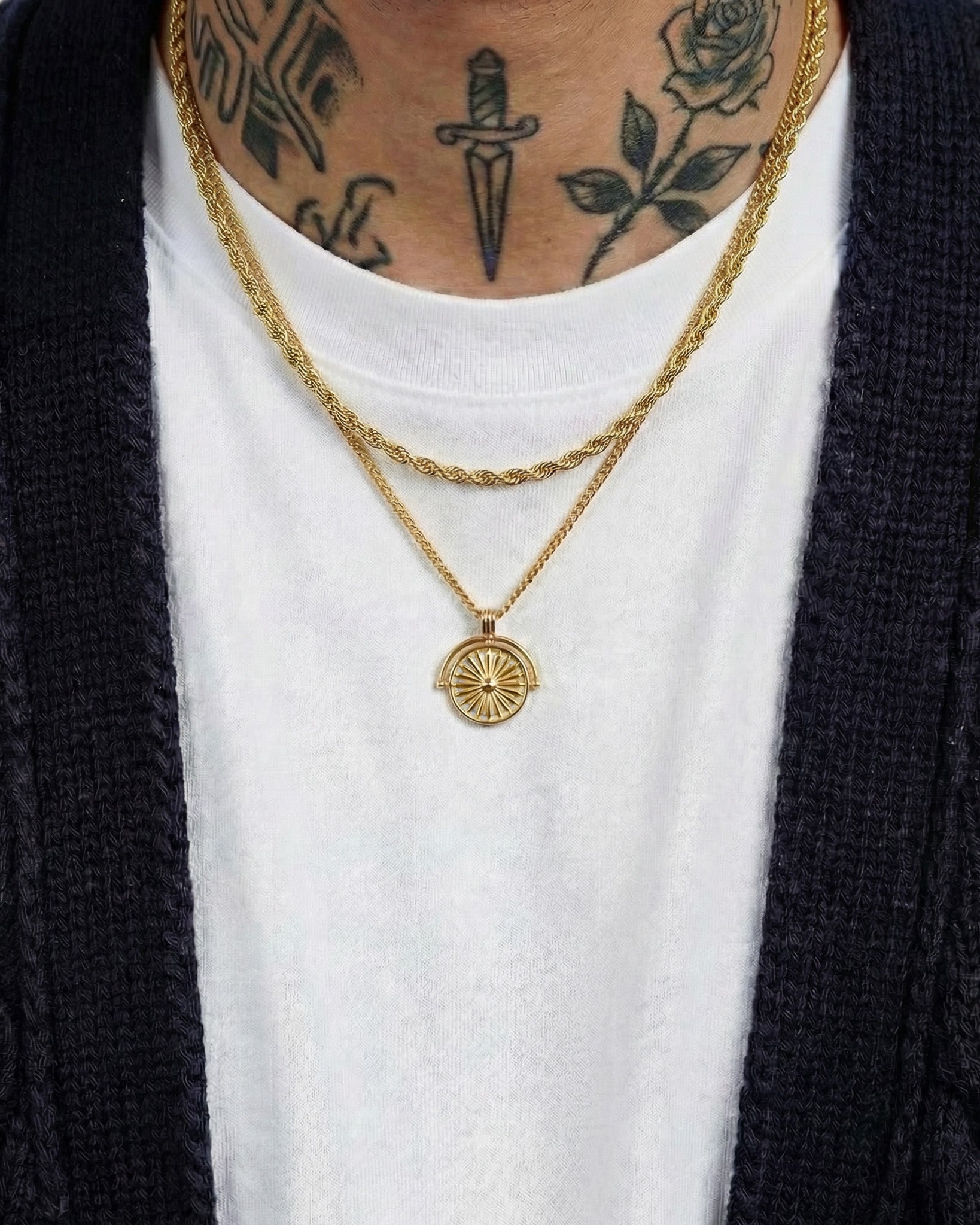 Daisy gold necklace with sunburst pendant worn on a tattooed neck