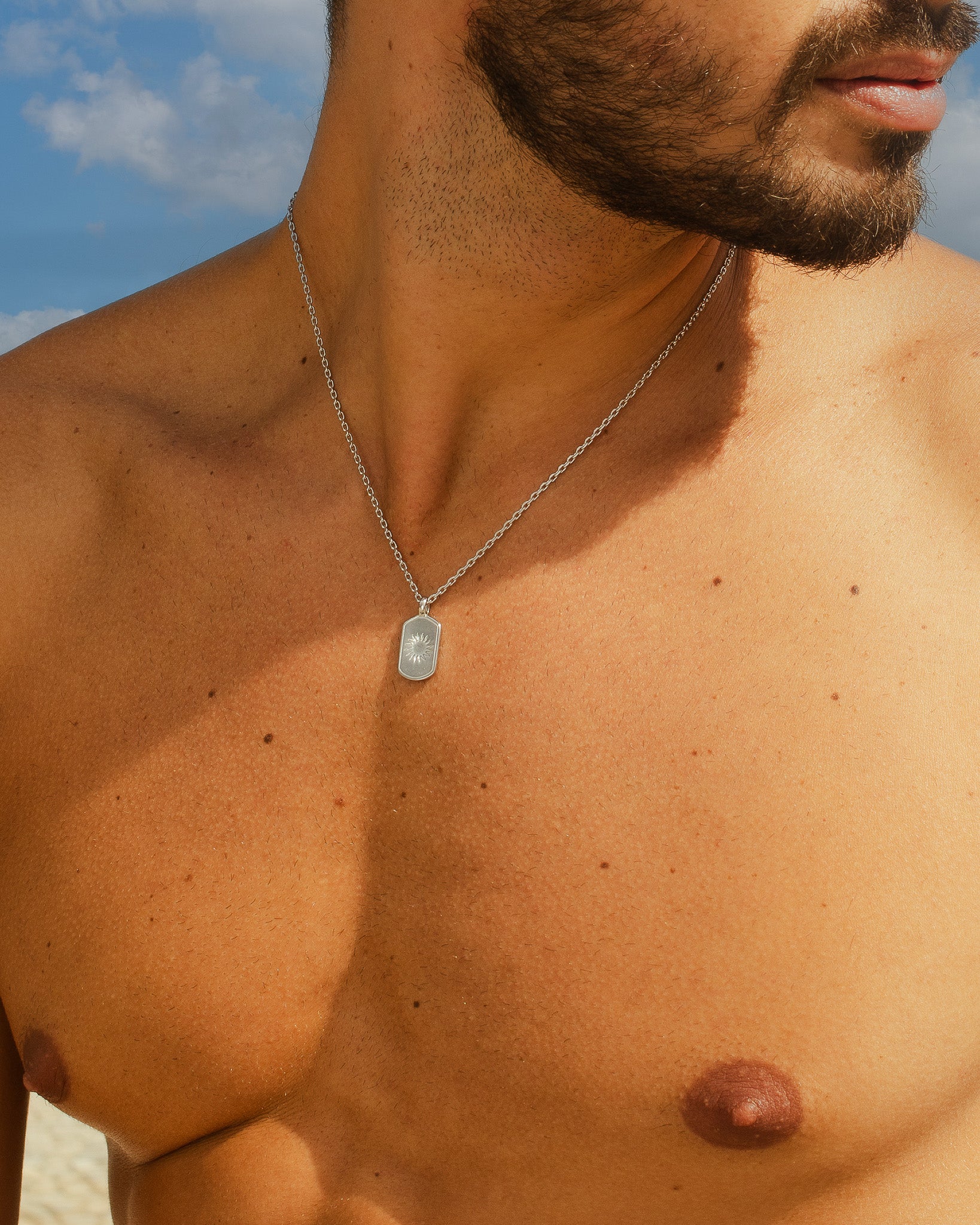 Daystar silver necklace with a rectangular pendant resting on the man's chest