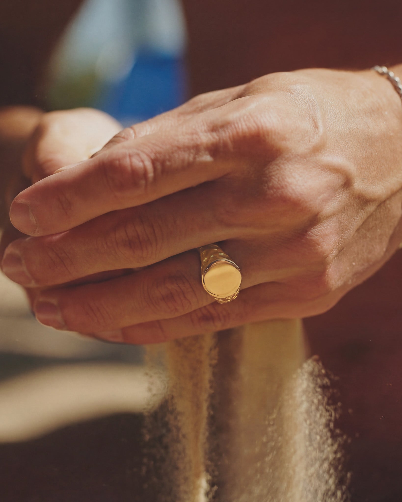 Eden Gold Ring on a finger with warm lighting and soft background
