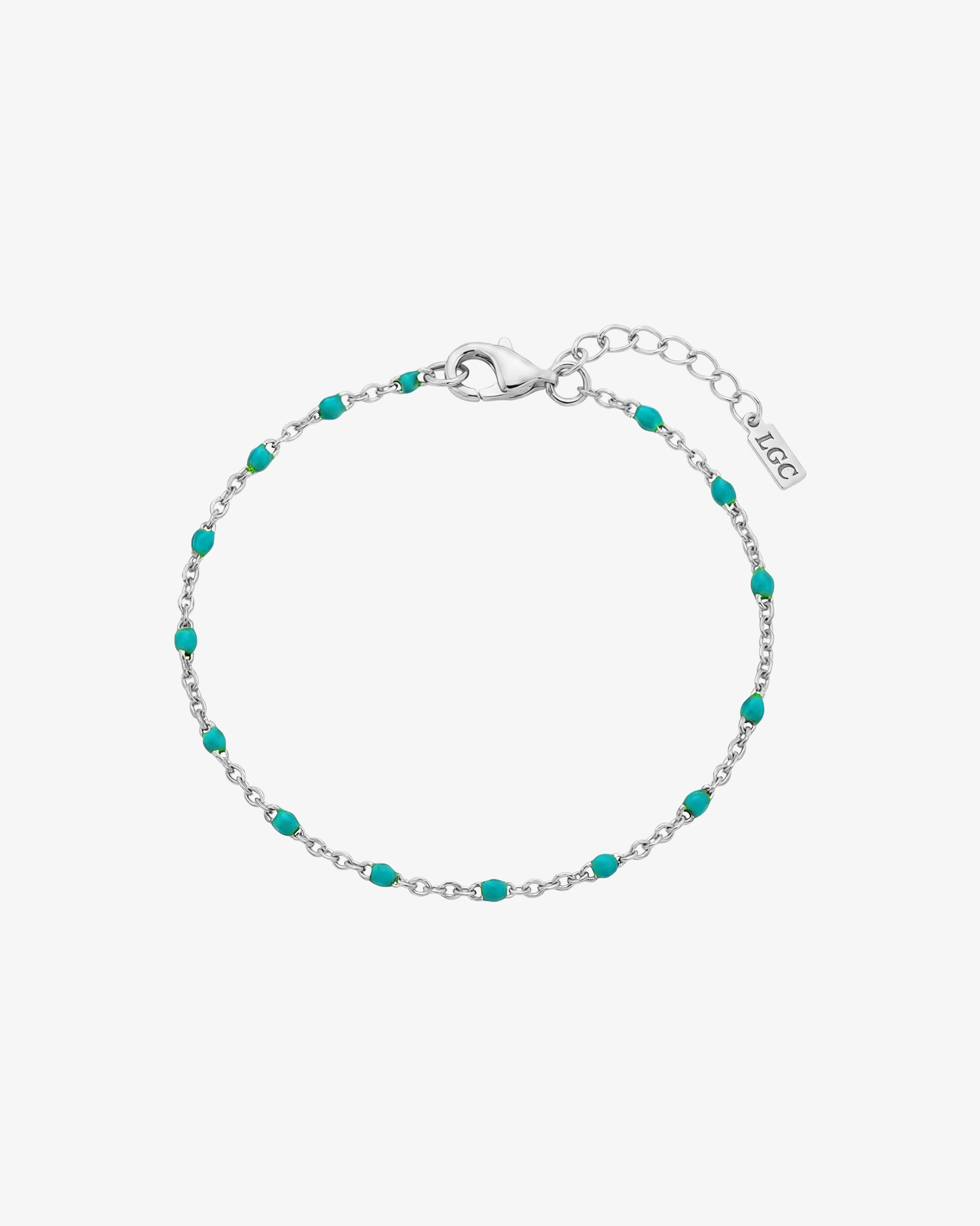 Silver bracelet with turquoise beads and a lobster clasp on a wrist