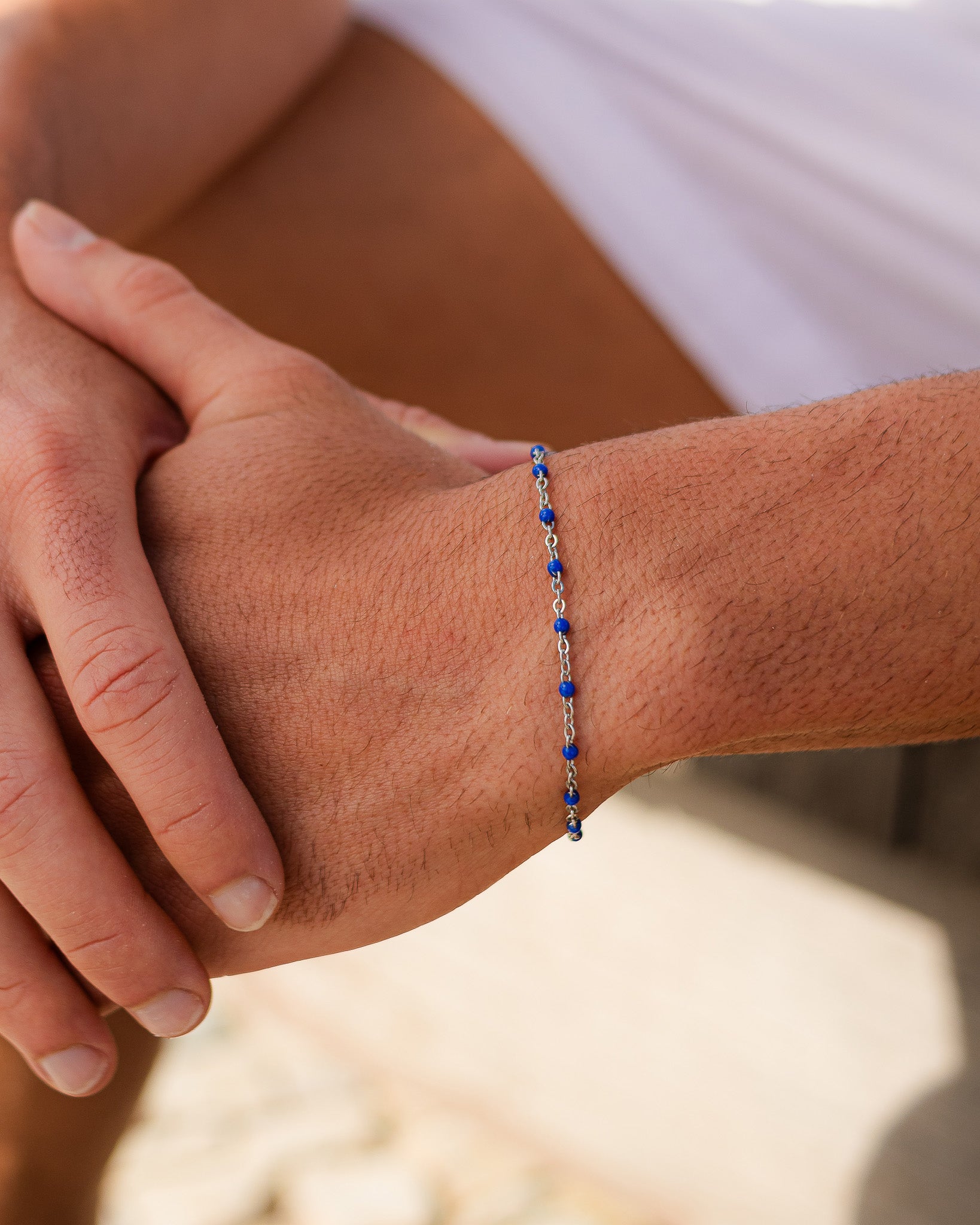 Silver bracelet with blue beads worn on the wrist
