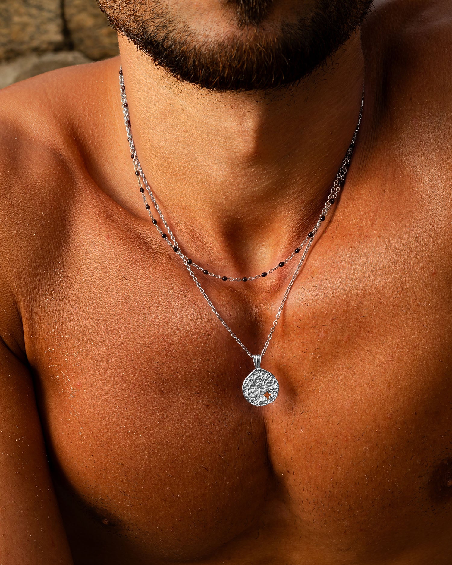 Collar MIST de plata con dos cadenas y colgante redondo texturizado en un cuello bronceado