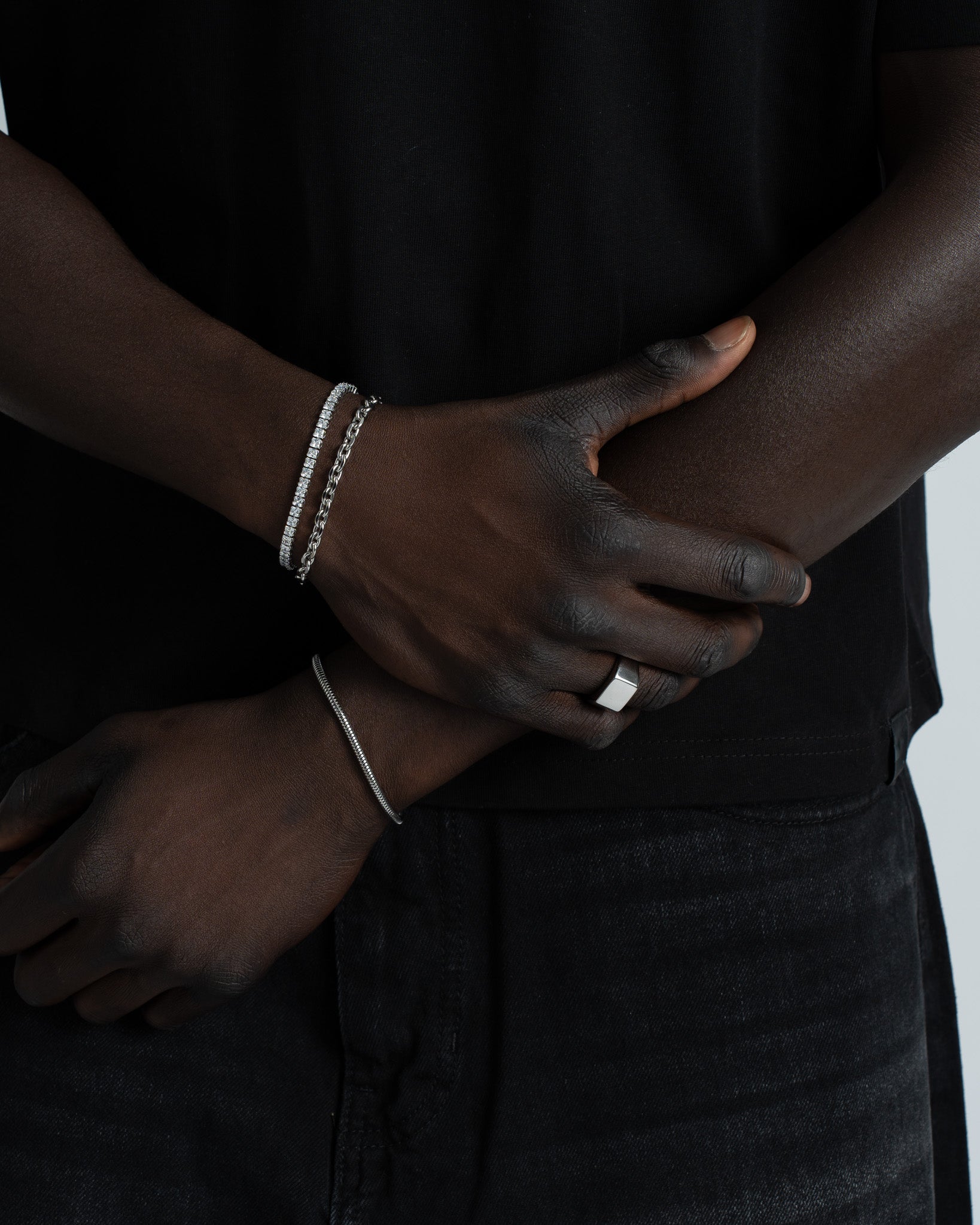 Sunset silver bracelet with row of stones worn on the wrist, paired with a slim silver chain