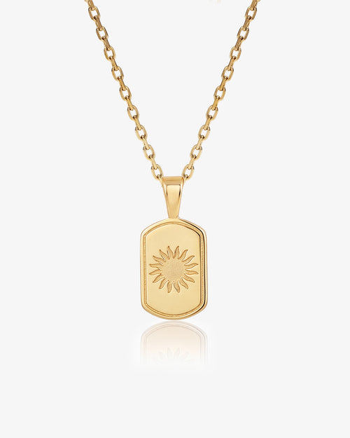 Daystar gold necklace with sunburst pendant on a gold chain.