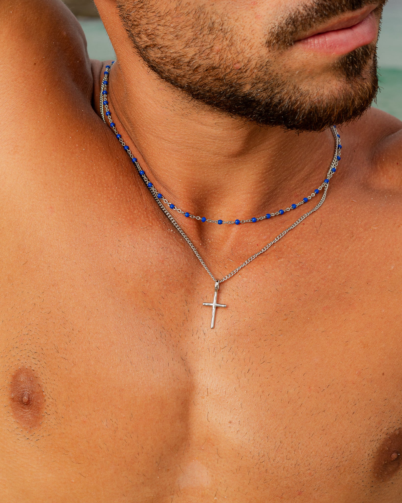 Close up of a turquoise bead silver chain necklace around the neck.