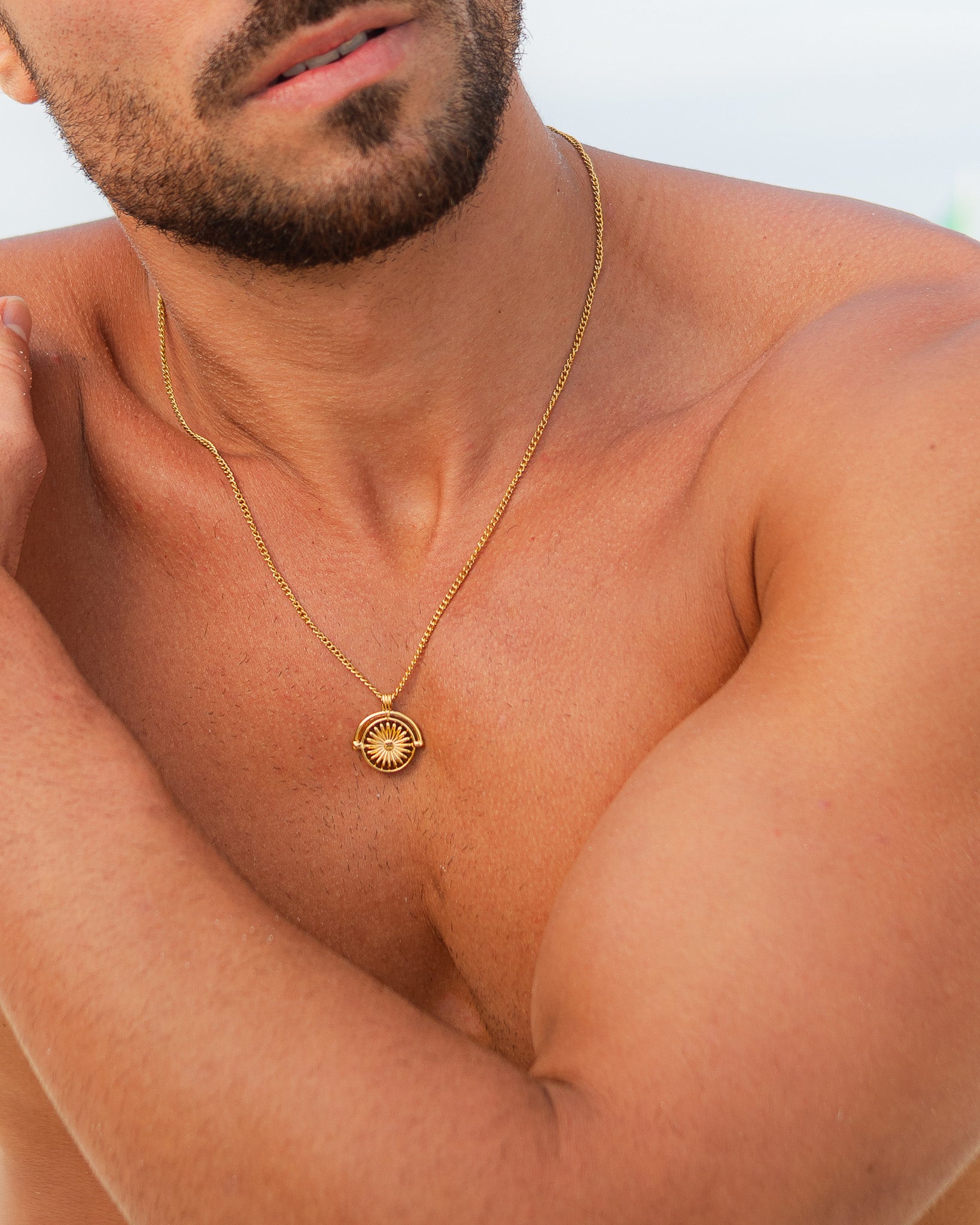 SIRA Gold necklace with a small round pendant resting on the chest.