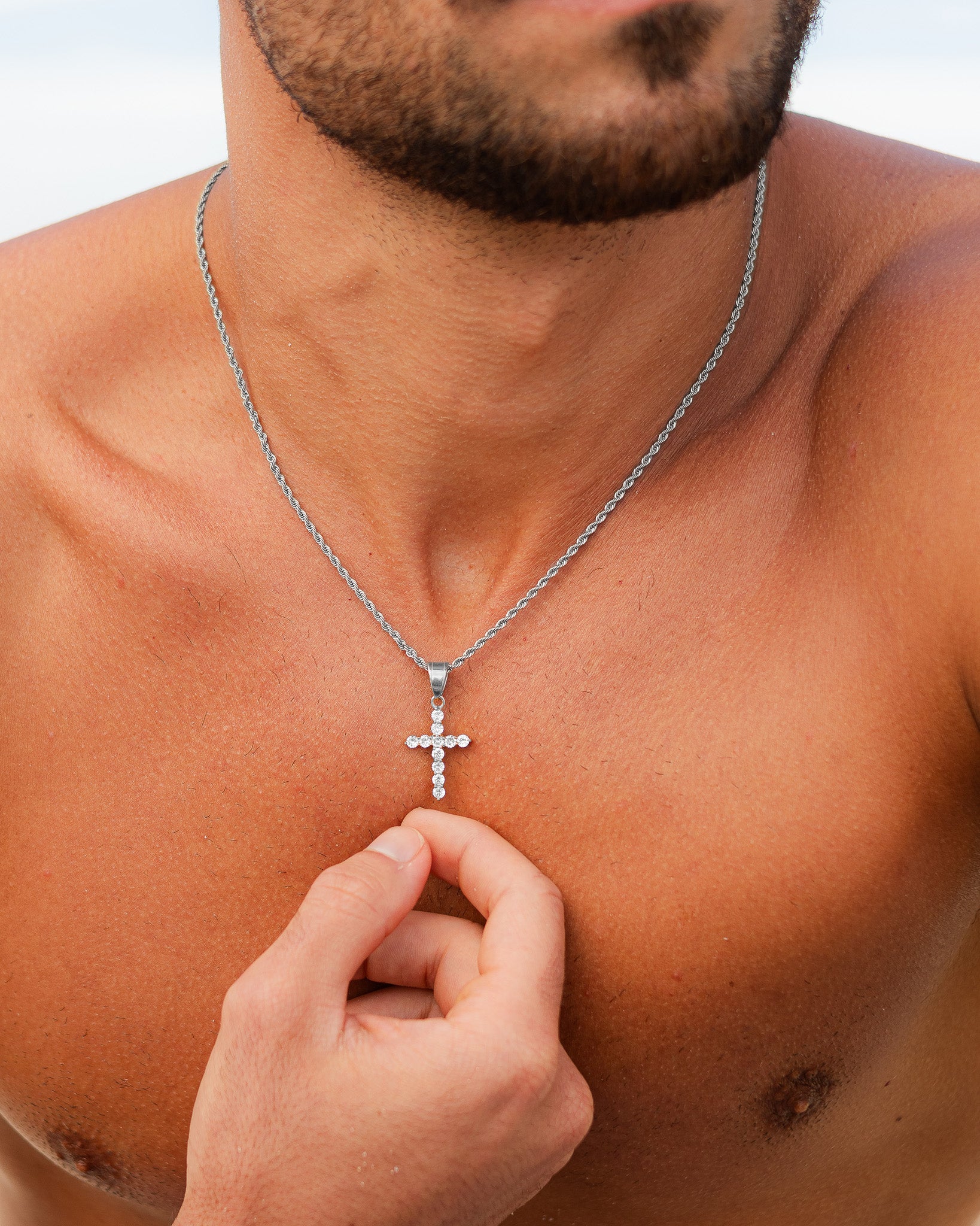 Icy Cross Silver Necklace with a crystal studded cross pendant resting on the chest