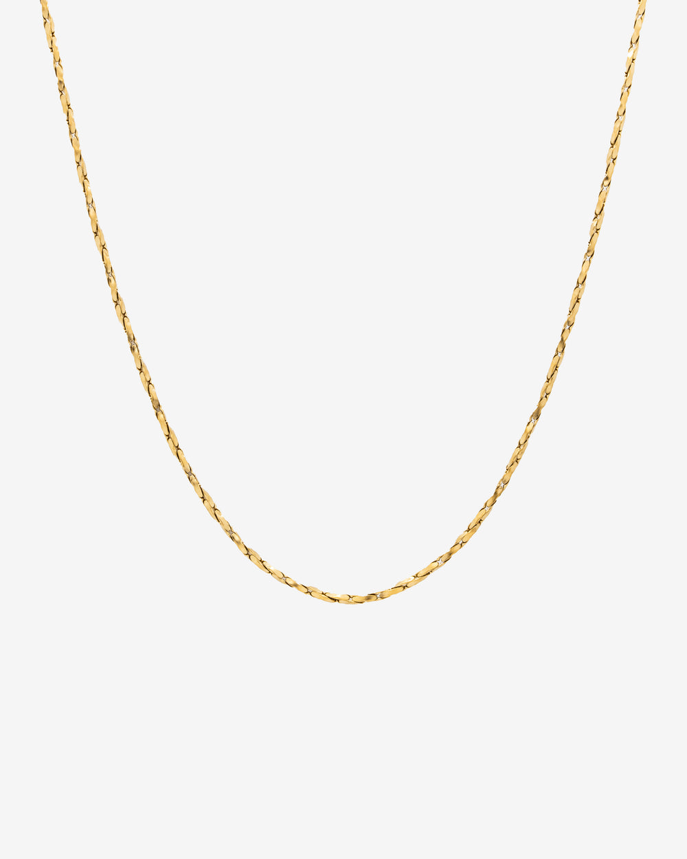 Cadena dorada minimal con perfil limpio de eslabones planos sobre fondo claro