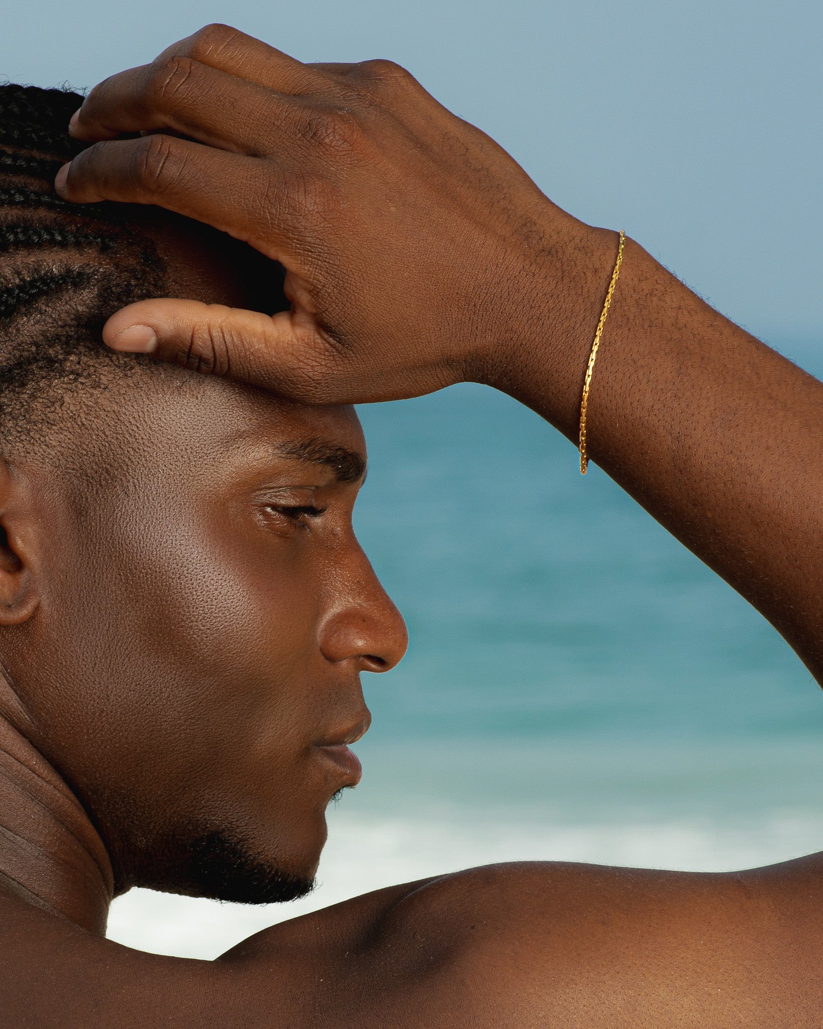 Gold LIRA bracelet worn on a forearm resting on a tree trunk