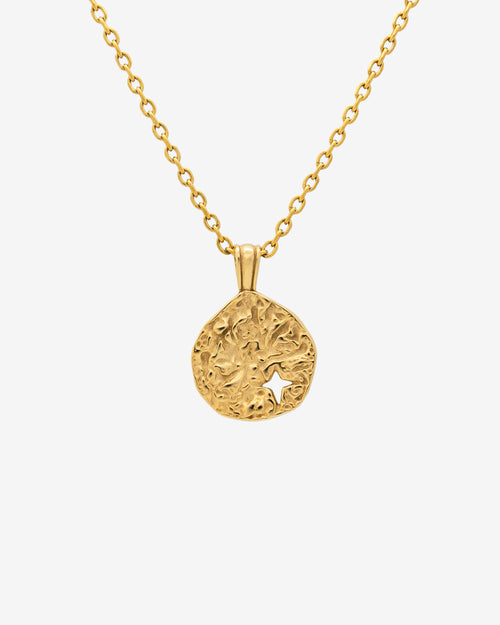 Close up of MIST GOLD NECKLACE with a textured round pendant and a star cutout on a 50 cm chain