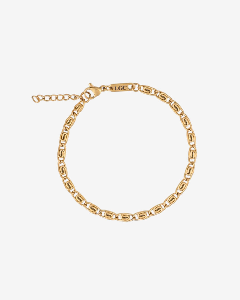 Pulsera dorada NUSA con cadena de eslabones gruesos en la muñeca sobre fondo blanco