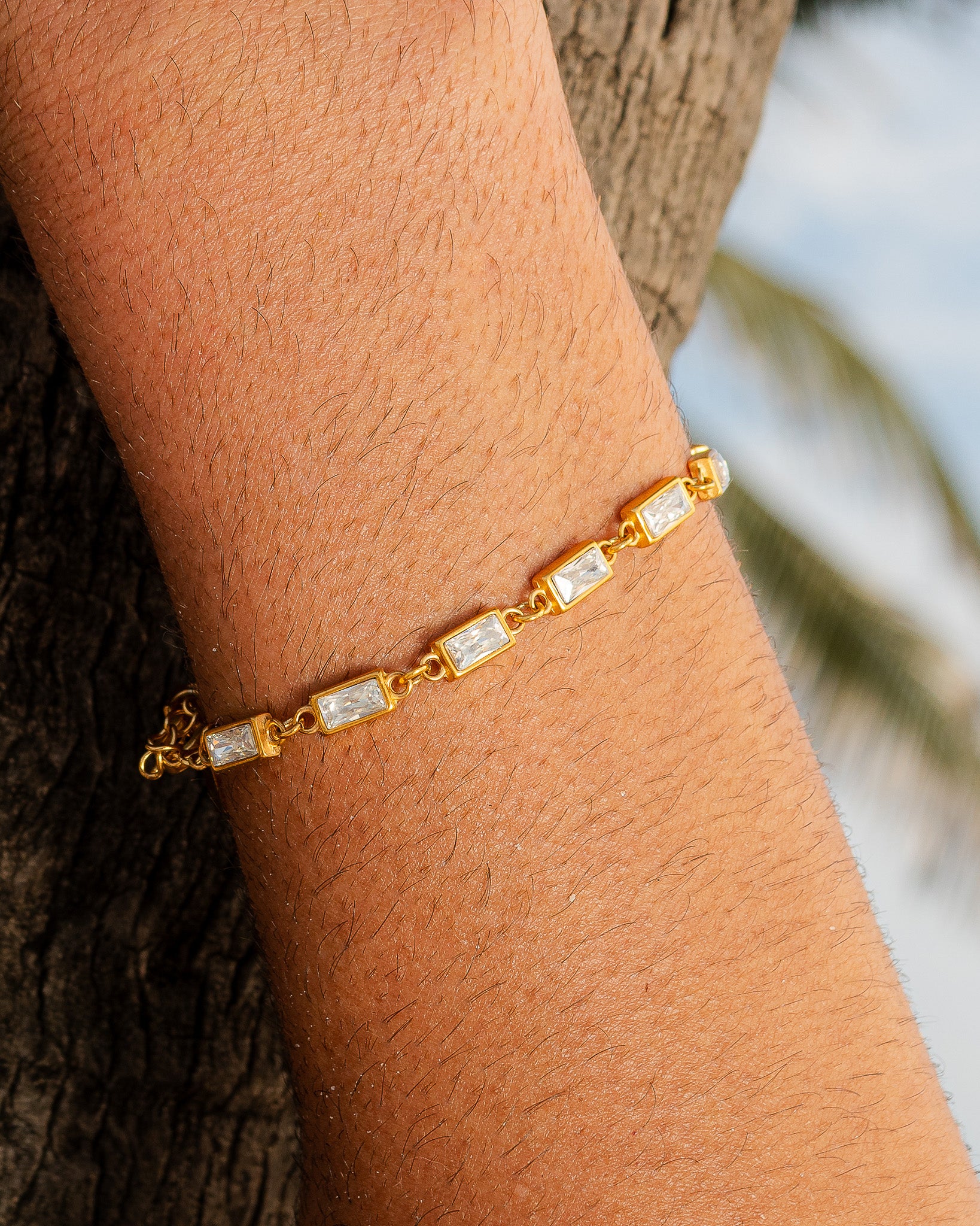 Gold OMEN bracelet with square crystal links on a wrist